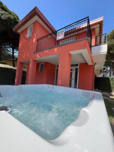 罗索利纳马雷Principesse的房子前面的房屋设有热水浴池