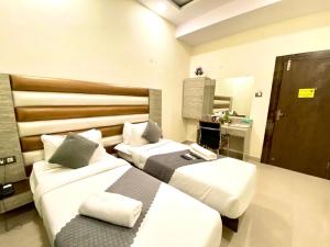 商沙巴Hotel Sky International- Airport Zone Hyderabad的酒店客房,设有两张床和镜子
