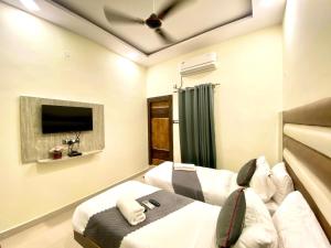 商沙巴Hotel Sky International- Airport Zone Hyderabad的一间卧室配有两张床和吊扇