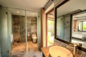 Hiếu NhơnEn Retreat Villa Hoi An的浴室配有盥洗盆和带镜子的淋浴
