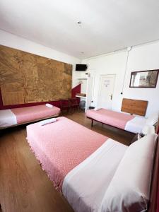 马德里广场之家旅馆的一间设有两张床和一张桌子的房间