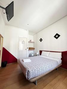 马德里广场之家旅馆的一间卧室配有一张床和一台平面电视