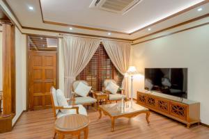 FuvahmulahAlafehi Retreat的客厅配有电视和桌椅