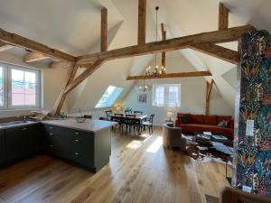 巴尔Le Hêtre Rouge Charme & Spa的厨房和带木梁的客厅