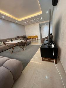 阿加迪尔Islane vue piscine的客厅配有沙发和桌子上的电视