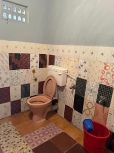 门格洛尔KENSON'S INN的浴室设有卫生间,墙上铺有瓷砖。