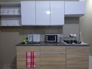 塔那那利佛Milestone City - Appartements à louer的厨房配有白色橱柜、水槽和微波炉