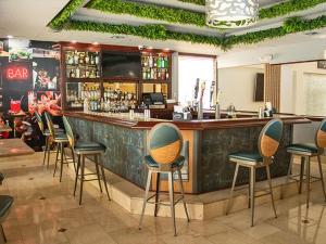 迈阿密Regency Miami Airport by Sonesta的餐厅内带绿椅的酒吧