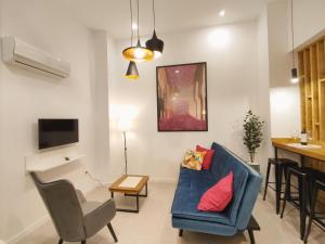 格拉纳达Ferola Homes的客厅配有蓝色的沙发和桌子