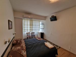 GrammatikovoКъща за гости Пантови的卧室配有一张床和一张桌子及椅子