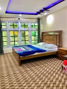 锡卡都Al Jannat Hotel & Relax Inn Guest House Skardu的一间卧室设有一张蓝色天花板的大床