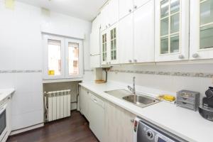 马德里Residencia Salamanca的厨房配有白色橱柜和水槽