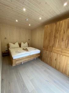 Lelis Alpenloft - Bergchalet in Halden的木制客房内的一间卧室,配有一张床