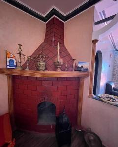 索维拉Charmante appartement privée的客厅里的一个红砖壁炉