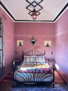 索维拉Charmante appartement privée的卧室配有一张粉红色墙壁上的床铺