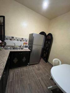 索维拉Charmante appartement privée的厨房配有冰箱、水槽和桌子