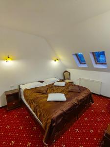 杜劳Hotel Bistrita的一间带一张大床的卧室,位于带窗户的房间内