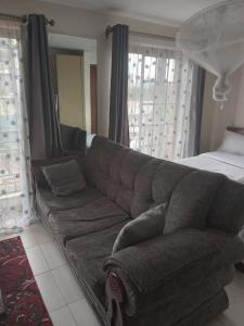 内罗毕Mvuli suites的客厅配有沙发和1张床