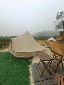 米哈斯Glamping Finca el Olivo的帐篷、野餐桌和长凳