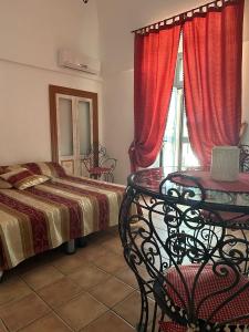 阿尔贝罗贝洛Il Sogno的一间卧室配有一张床、一张桌子和一个窗户。