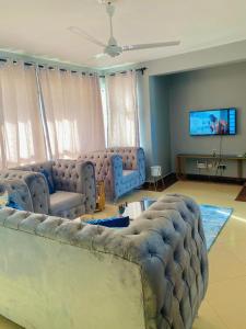 蒙巴萨Danmic的客厅配有大沙发和平面电视