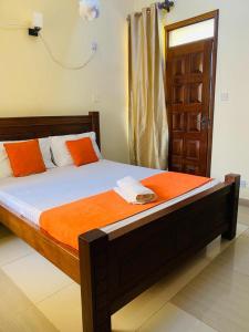 蒙巴萨Danmic的一间卧室配有橙色和白色床单。