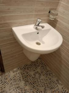 TezoOpaque gardens的浴室设有白色水槽,铺有瓷砖地板。