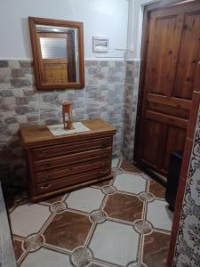 MostaganemMAISON DE VACANCE的一间带木制梳妆台和镜子的浴室
