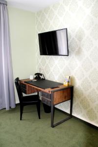 索内贝格索奈贝格斯皮尔酒店的一张桌子,墙上有一台电视,椅子