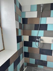 OrissaareSunset Bungalow的浴室设有色彩缤纷的瓷砖淋浴。