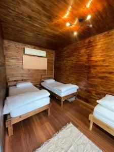 特拉布宗Trabzon Silent Hill Bungalow的一间设有三张床和木墙的房间