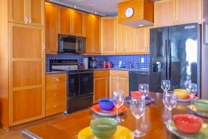 加尔维斯敦Islander East Condominiums的厨房配有木制橱柜和酒杯桌子