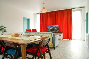 谢赫维蒂利Villa Capri-Kaprovani的一间设有桌子和红色窗帘的用餐室