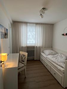 阿克斯姆Landhus-Sylt的一间卧室配有一张床、一张书桌和一个窗户。
