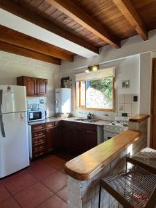 圣马丁德洛斯Huilen de Bandurrias的厨房配有白色冰箱和桌子