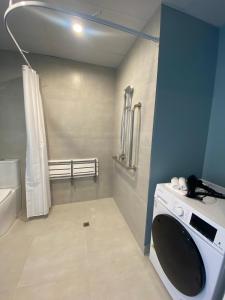 奥克兰La Quinta by Wyndham Parnell Auckland的洗衣房,浴室内配有洗衣机