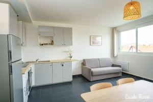 迈松阿尔福escale-marne fr - 11 - Appartement entier, 4 pers, 10mn metro 8, RER A, Parking rue Gratuit, Cuisine Équipée, Grand lit haut de gamme, Matelas Eve Sleep, 1er étage的厨房配有冰箱、桌子和椅子