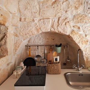 弗兰卡维拉丰塔纳Residenza Anima Mediterranea的一个带水槽和石墙的厨房