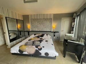 斯蓬坦勒博查特 - 奥雷尔住宿加早餐酒店的卧室配有牛印花床和书桌