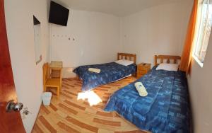 帕拉卡斯Starfish of Paracas的一间设有两张床和电视的房间