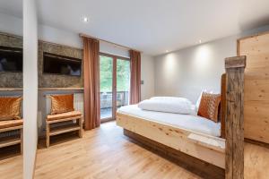 萨尔图西奥圣乌尔苏拉酒店的一间卧室配有木床和电视