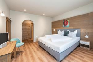 萨尔图西奥圣乌尔苏拉酒店的一间卧室配有一张床、一张书桌和一台电视