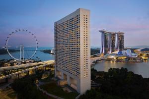 新加坡The Ritz-Carlton, Millenia Singapore的一座高大的建筑,在城市里装有摩天轮