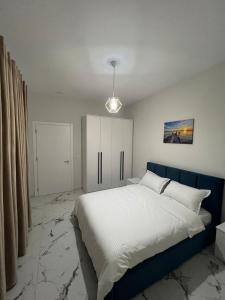 LushnjëPrime Luxury Apartments的一间卧室配有一张大床和蓝色床头板