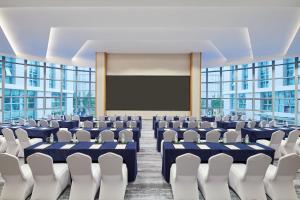 广州广州空港万枫酒店的一个带椅子和投影屏幕的会议室