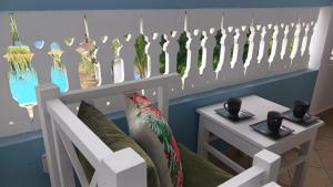 迪亚尼海滩Bedroom Diani Beach的一间设有白色长凳和茶几及杯子的房间