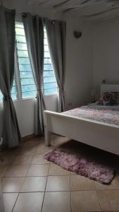 迪亚尼海滩Bedroom Diani Beach的一间卧室配有床和带窗帘的窗户