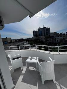 LushnjëPrime Luxury Apartments的阳台配有桌椅,享有城市美景。
