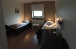 基律纳E-10酒店的小房间设有两张床和窗户