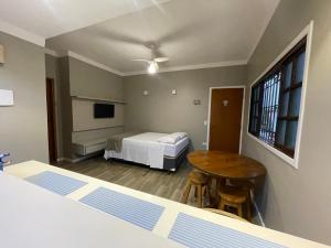 乌巴图巴Chilli Brasil Suite的配有床、桌子和床的房间